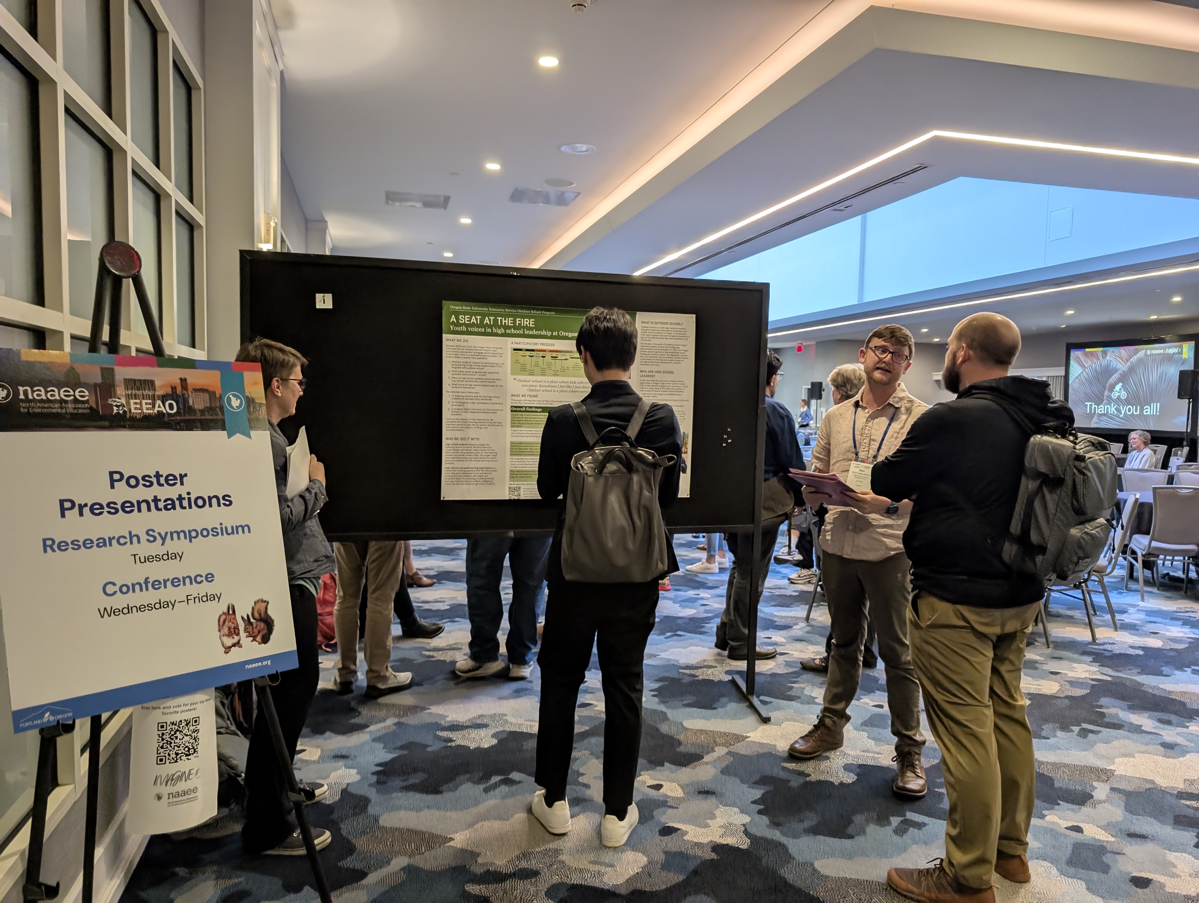 Sign shows "Poster Presentations Research Symposium"